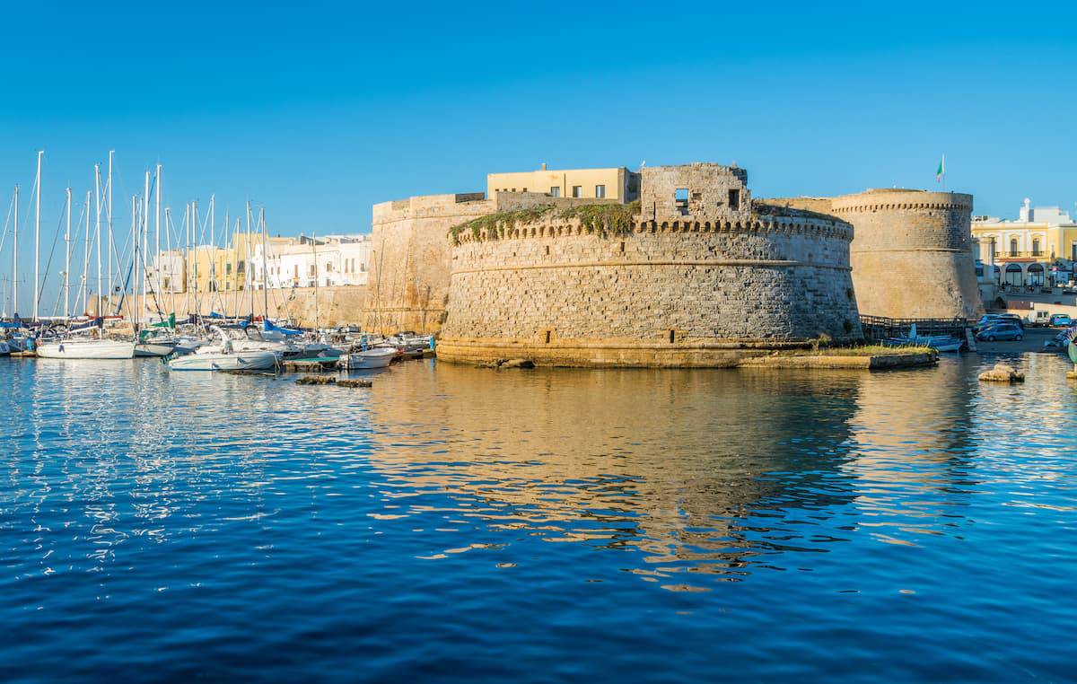 Vista del centro storico di Gallipoli dal mare, con le mura e la cattedrale al tramonto