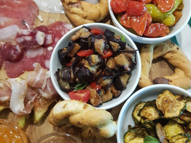 Pasticciotti appena sfornati, puccia salentina e burrata su un tavolo di legno